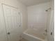 Bright bathroom with a tub-shower and white tiled walls at 10673 Alondra Peak St, Las Vegas, NV 89183