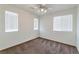 Bright bedroom with neutral carpet, ceiling fan, and three windows providing natural light at 10673 Alondra Peak St, Las Vegas, NV 89183