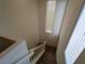 View from the top of the carpeted staircase with a tall window providing natural light at 10673 Alondra Peak St, Las Vegas, NV 89183