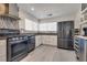 Modern kitchen featuring stainless steel refrigerator and range, white cabinets, and light gray flooring at 109 Clifton Heights Dr, Las Vegas, NV 89145