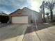 Charming single-story home with a two-car garage, desert landscaping, and mature palm trees in a sunny setting at 1210 Country Club, Laughlin, NV 89029