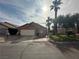 Charming single-story home with a two-car garage, desert landscaping, and mature palm trees in a sunny setting at 1210 Country Club, Laughlin, NV 89029