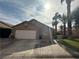 Charming single-story home with a two-car garage, desert landscaping, and mature palm trees in a sunny setting at 1210 Country Club, Laughlin, NV 89029