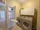 Well-equipped laundry room with modern appliances, a fold-away ironing board, and extra storage cabinets at 1210 Country Club, Laughlin, NV 89029