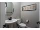 Powder room with pedestal sink, round mirror, and decorative framed art at 12495 Point Sierra St, Las Vegas, NV 89138