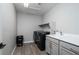 Functional laundry room with modern washer and dryer, sink, and ample storage space at 12495 Point Sierra St, Las Vegas, NV 89138