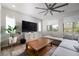 Spacious living room with a large sectional couch, modern ceiling fan and a wooden coffee table at 12495 Point Sierra St, Las Vegas, NV 89138