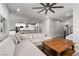 Spacious living room with a large sectional sofa, wood floors, and modern ceiling fan at 12495 Point Sierra St, Las Vegas, NV 89138