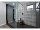 Modern shower with black and white patterned tile, a glass enclosure, and a convenient wooden bench at 12495 Point Sierra St, Las Vegas, NV 89138