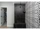 Stylish shower with black marble-look tile and patterned tile, glass doors, and modern fixtures at 12495 Point Sierra St, Las Vegas, NV 89138