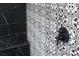 Close-up of shower featuring black and white patterned tile and dark fixtures, highlighting modern design at 12495 Point Sierra St, Las Vegas, NV 89138