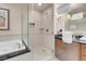 Bright bathroom features a luxurious soaking tub, glass enclosed shower and neutral toned tile at 125 E Harmon Ave # 2215, Las Vegas, NV 89109