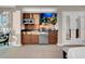 Cozy kitchenette features wood cabinetry, a mini-fridge, a microwave, and a wall-mounted TV at 125 E Harmon Ave # 2215, Las Vegas, NV 89109
