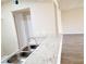 Galley kitchen with granite countertop with stainless steel sink and grey wood floor at 1450 Hialeah Dr # D, Las Vegas, NV 89119