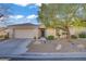 Inviting home featuring a well-manicured yard, mature landscaping, and a paved driveway at 205 Derwent Pl, Las Vegas, NV 89144