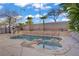 Backyard pool and spa with rock surround, palm trees, and desert landscaping at 205 Derwent Pl, Las Vegas, NV 89144