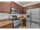Kitchen features stainless steel appliances, including a microwave and gas range, with granite countertops and brown cabinets at 2050 W Warm Springs Rd # 1822, Henderson, NV 89014