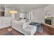 Bright living room features fireplace, white sofa, dark floors, and view of dining room at 2050 W Warm Springs Rd # 1822, Henderson, NV 89014