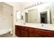 Bathroom with dual sinks, wood vanity, large mirror and tiled shower and bath combo at 2105 Harbor Cliff Dr, Las Vegas, NV 89128