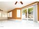 Bright living room featuring white tile flooring, shuttered windows, and a sliding glass door at 2105 Harbor Cliff Dr, Las Vegas, NV 89128