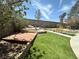 Beautiful backyard showcasing lush green lawn, mature trees, and custom hardscape elements at 2429 Worchester Rd, Henderson, NV 89074
