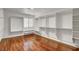 Walk-in closet with custom shelving, seating, and laminate wood flooring at 2505 Palmridge Dr, Las Vegas, NV 89134