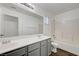 Bathroom featuring a double sink vanity, large mirror, and shower-tub combination at 2612 Kindness Ct, North Las Vegas, NV 89031