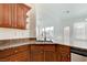 Updated kitchen featuring a stainless steel sink, granite countertops, and wood cabinets at 2612 Kindness Ct, North Las Vegas, NV 89031