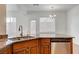 Kitchen sink featuring granite countertops, a stainless steel dishwasher, wood cabinetry and modern lighting at 2612 Kindness Ct, North Las Vegas, NV 89031