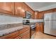Close up of a kitchen with stainless steel appliances, wood cabinetry and granite countertops at 2612 Kindness Ct, North Las Vegas, NV 89031