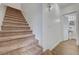 Carpeted staircase featuring wood floors in the hallway and a bathroom at 2612 Kindness Ct, North Las Vegas, NV 89031