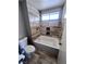 Clean bathroom featuring tiled walls, a bathtub with a shower and a window at 3324 Haven Beach Way, Las Vegas, NV 89117