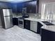 Modern kitchen featuring stainless steel appliances, granite countertops, and dark cabinetry at 3324 Haven Beach Way, Las Vegas, NV 89117