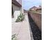 View of side yard featuring a walkway with concrete pavers and stone landscaping adjacent to a block wall at 3324 Haven Beach Way, Las Vegas, NV 89117
