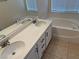 Bathroom with double sink vanity, soaking tub, and tile flooring at 3641 Spring Day Ct, Las Vegas, NV 89147