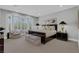Spacious bedroom featuring plush carpet, a large window seat, and elegant dark wood furniture at 4430 Angelo Rosa St, Las Vegas, NV 89135
