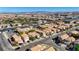 An aerial perspective of a neighborhood featuring well-maintained homes, and the Las Vegas skyline far off in the distance at 5438 Jacobs Field St, Las Vegas, NV 89148