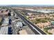 An aerial view shows homes, stores, parking lots, and a wide thoroughfare under a clear blue sky, with mountains in the distance at 5438 Jacobs Field St, Las Vegas, NV 89148