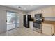 Cozy kitchen with stainless steel appliances, tiled floors, and a sliding glass door to the backyard at 5438 Jacobs Field St, Las Vegas, NV 89148