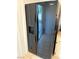 Modern kitchen featuring a black Whirlpool refrigerator with water dispenser, tiled floor, and cabinets at 5438 Jacobs Field St, Las Vegas, NV 89148