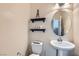 Charming powder room features a pedestal sink, decorative shelves, and stylish decor at 5556 Cornadelo Range Rd, Las Vegas, NV 89113