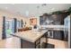 A beautiful kitchen with a granite topped island featuring bar seating, stainless appliances, and dark wood cabinets at 5556 Cornadelo Range Rd, Las Vegas, NV 89113