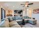 Open-concept living area that features an oversized comfortable sectional and modern finishes at 5556 Cornadelo Range Rd, Las Vegas, NV 89113