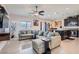 Spacious living room with a large sectional couch, ceiling fan, and tile flooring at 5556 Cornadelo Range Rd, Las Vegas, NV 89113