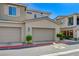 Attached two-car garages with neutral doors, framed by well-kept landscaping and a clearly marked fire lane at 5730 Sky Pointe Dr # 104, Las Vegas, NV 89130