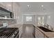 Open concept kitchen with granite countertops, stainless steel appliances, and tile flooring extending to the living area at 5730 Sky Pointe Dr # 104, Las Vegas, NV 89130