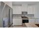 Modern kitchen featuring stainless steel appliances, granite countertops, and sleek white cabinetry at 5730 Sky Pointe Dr # 104, Las Vegas, NV 89130