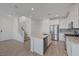 Bright, open living space features wood-look tile flooring, stairs to the second floor, and a modern kitchen at 5730 Sky Pointe Dr # 104, Las Vegas, NV 89130