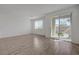 Bright, open-concept living area with wood-look flooring and sliding glass doors to the balcony at 5730 Sky Pointe Dr # 104, Las Vegas, NV 89130