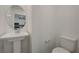 Cozy powder room showcasing a pedestal sink, round mirror, and convenient commode at 5730 Sky Pointe Dr # 104, Las Vegas, NV 89130